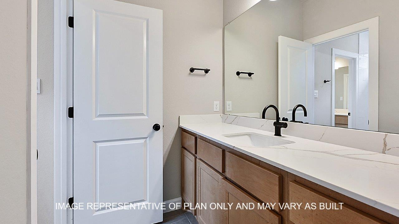Stratford secondary bathroom with light stained cabinets, white quartz countertops and matte black fixtures.