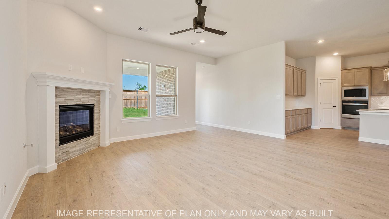 Weston living with fireplace, ceiling fan, and view to kitchen.