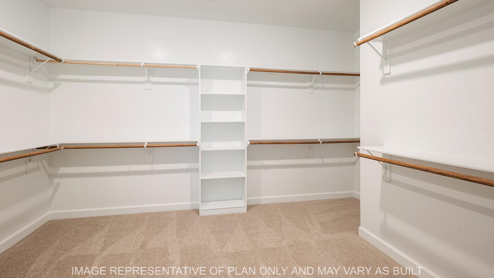 Weston primary walk-in closet with hanging space, storage shelves, and carpeted flooring.