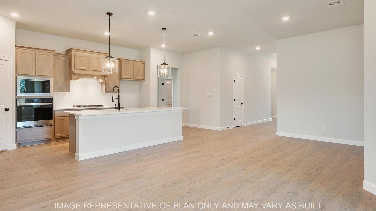 Weston kitchen and dining space with wood laminate flooring and can lights.