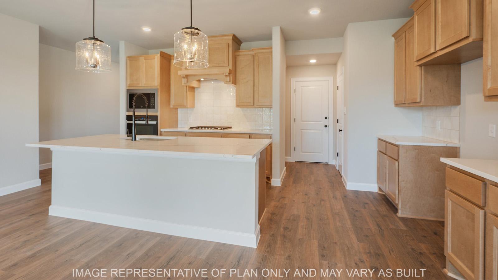 Norwood kitchen with pendent lighting, gas range, and oversized island.