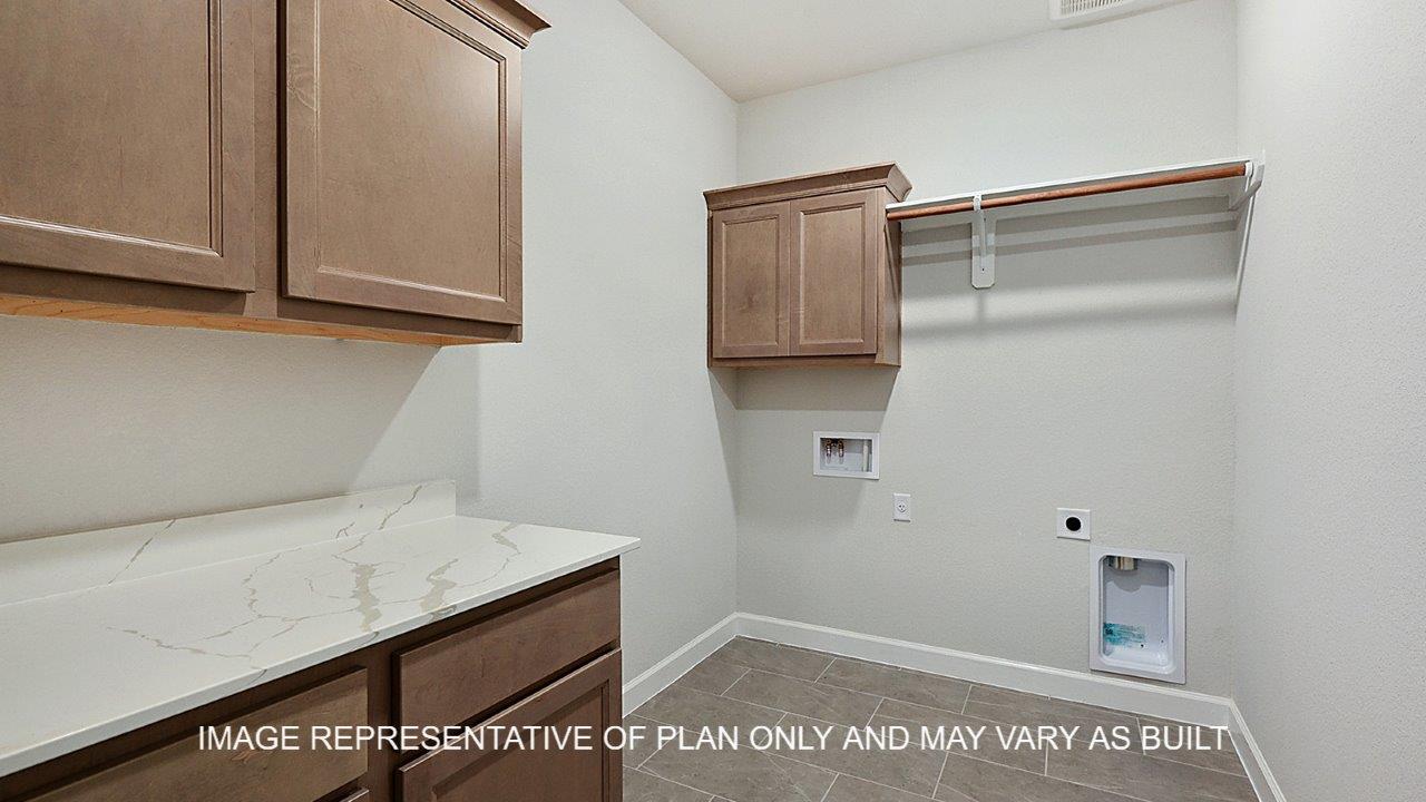 Kensington utility room with light stained cabinets, white quartz countertop with hanging rack for clothing.