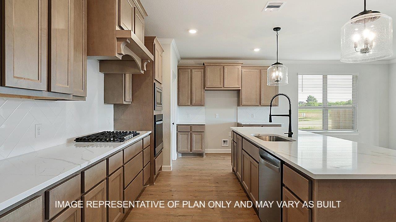 Kensington kitchen with light stained cabinets, white herringbone backsplash, quartz countertops and laminate wood flooring.