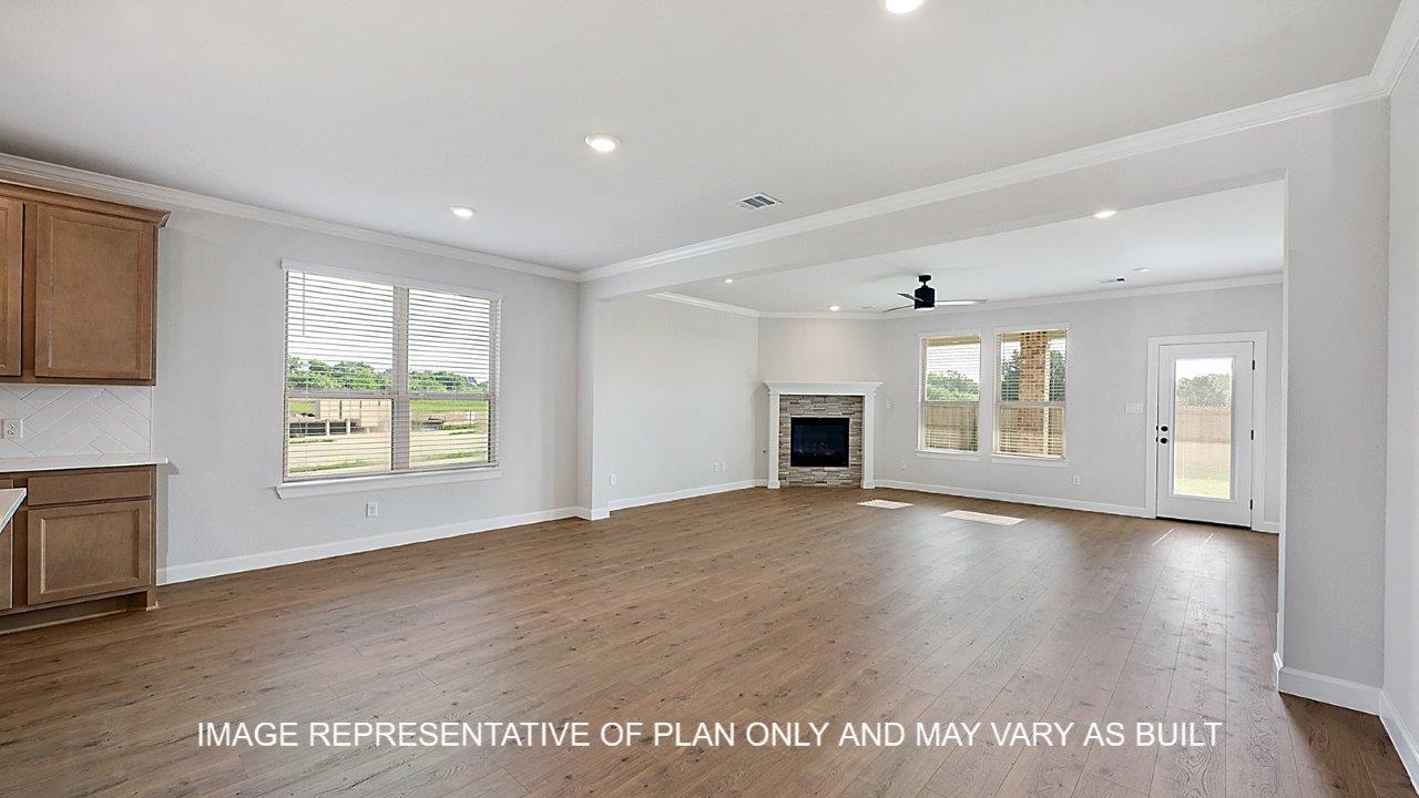 Kensington open concept living and dining room with corner fireplace and view into backyard.