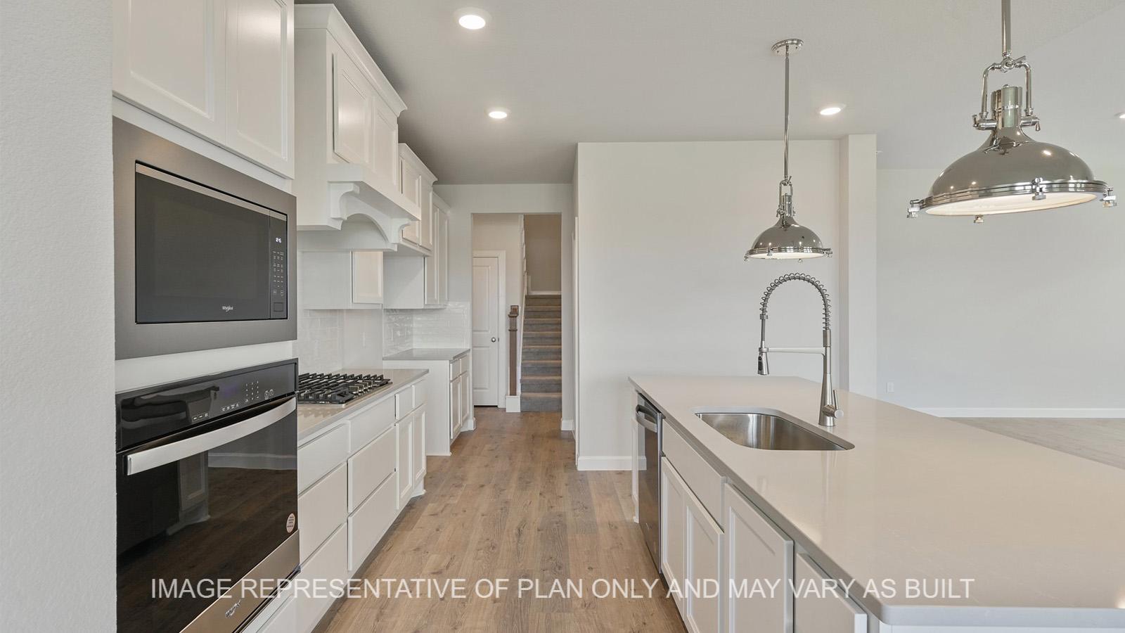 Hampton kitchen with laminate flooring and quarts countertops, with view to secondary staircase.