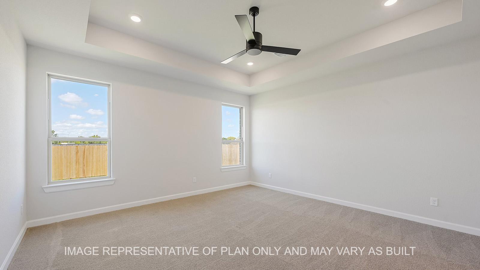 Hampton primary bedroom with two windows, carpeted flooring, and ceiling fan.