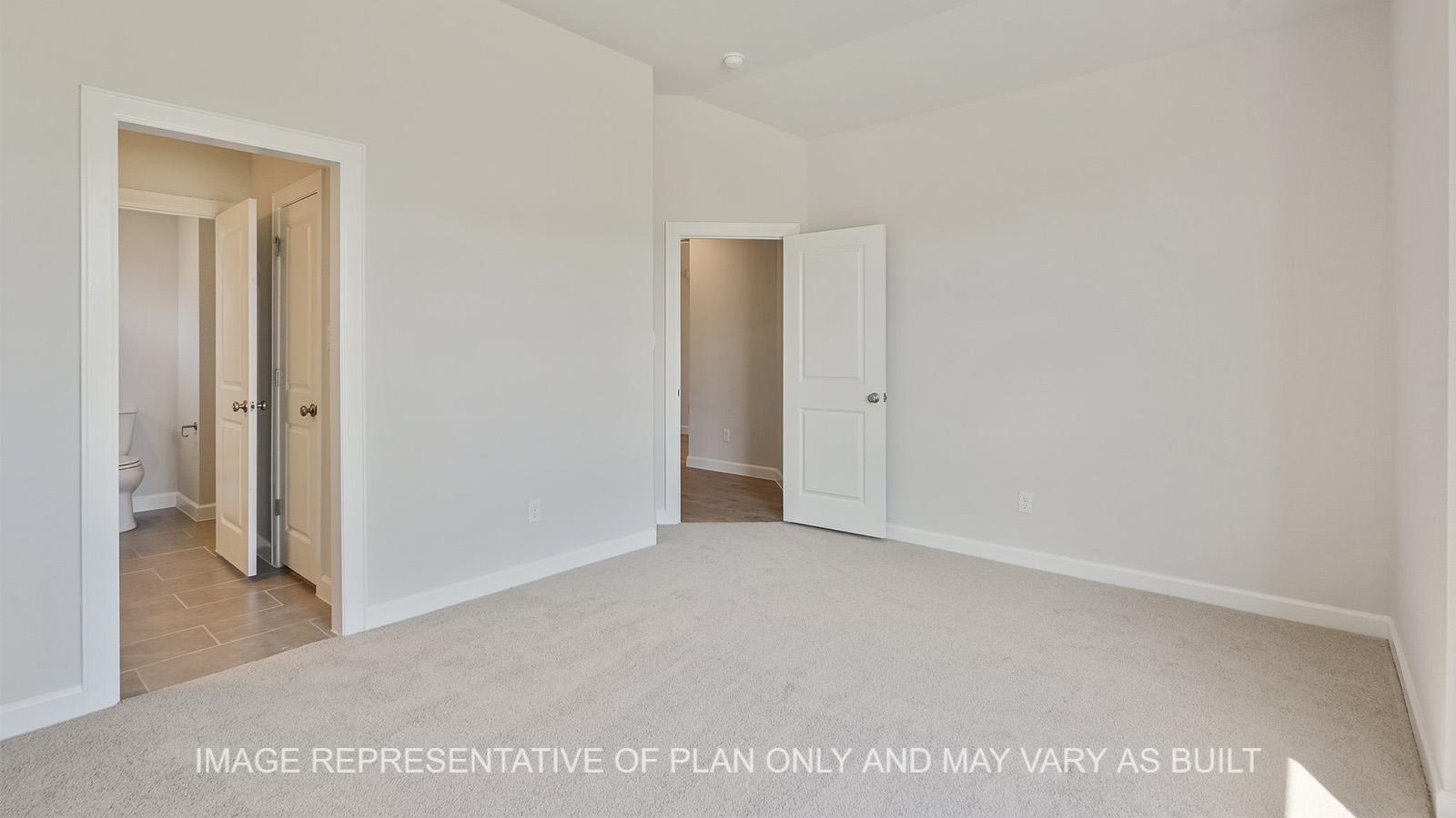 Hampton downstairs secondary bedroom with carpeted flooring and view to bathroom.
