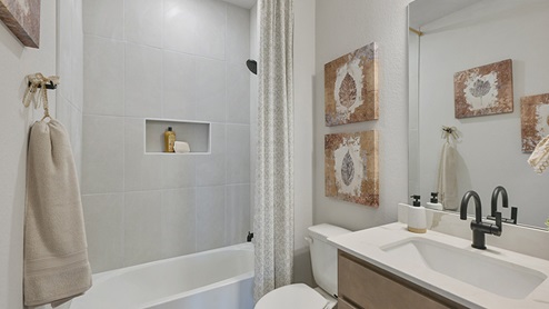 Secondary bathroom with ceramic tile surround on shower.