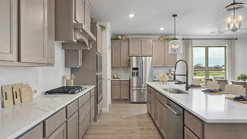 Large kitchen with white quartz and stained cabinets and large island.