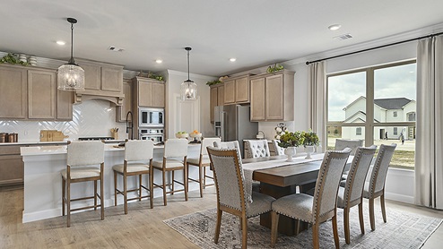 Open concept kitchen and dining with large window.
