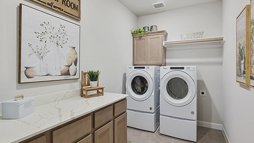 Spacious utility room with cabinets and quartz tops.