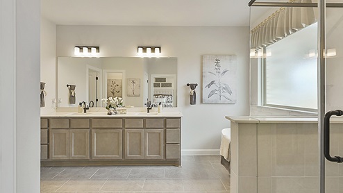 Beautiful primary bathroom with dual vanities and separate free-standing tub and shower.