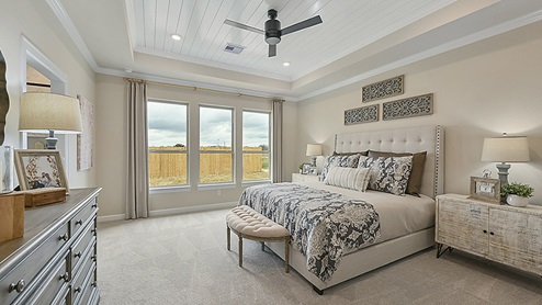 Large primary bedroom with ceiling detail and bay windows