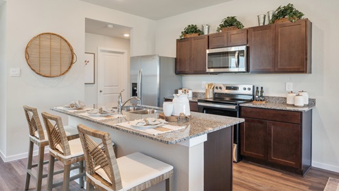 Cornerstone Caroline Kitchen with granite countertops and dark stained cabinetry.