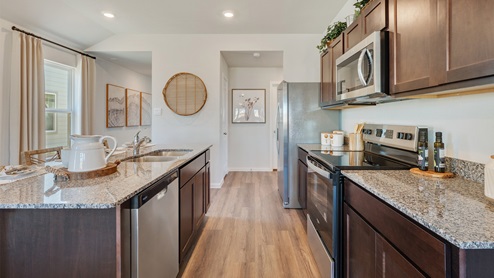 Cornerstone Caroline Kitchen with granite countertops and dark stained cabinetry.