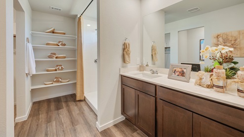 Cornerstone Caroline primary Bathroom with walk-in shower and linen shelving.