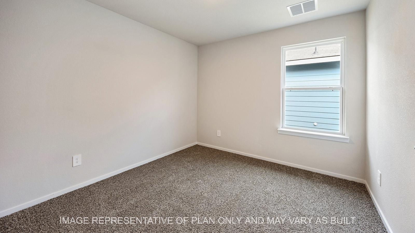 Amber secondary bedroom with window and carpeted flooring.