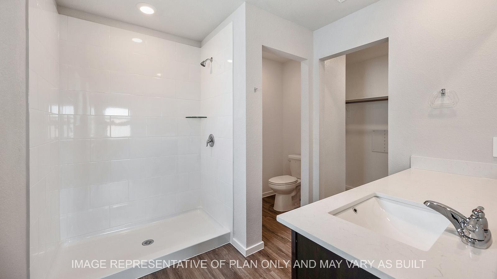 Amber primary bathroom with ceramic tile shower surround.