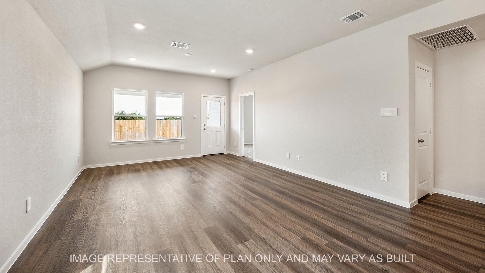 Amber open-concept living room with windows and back door.
