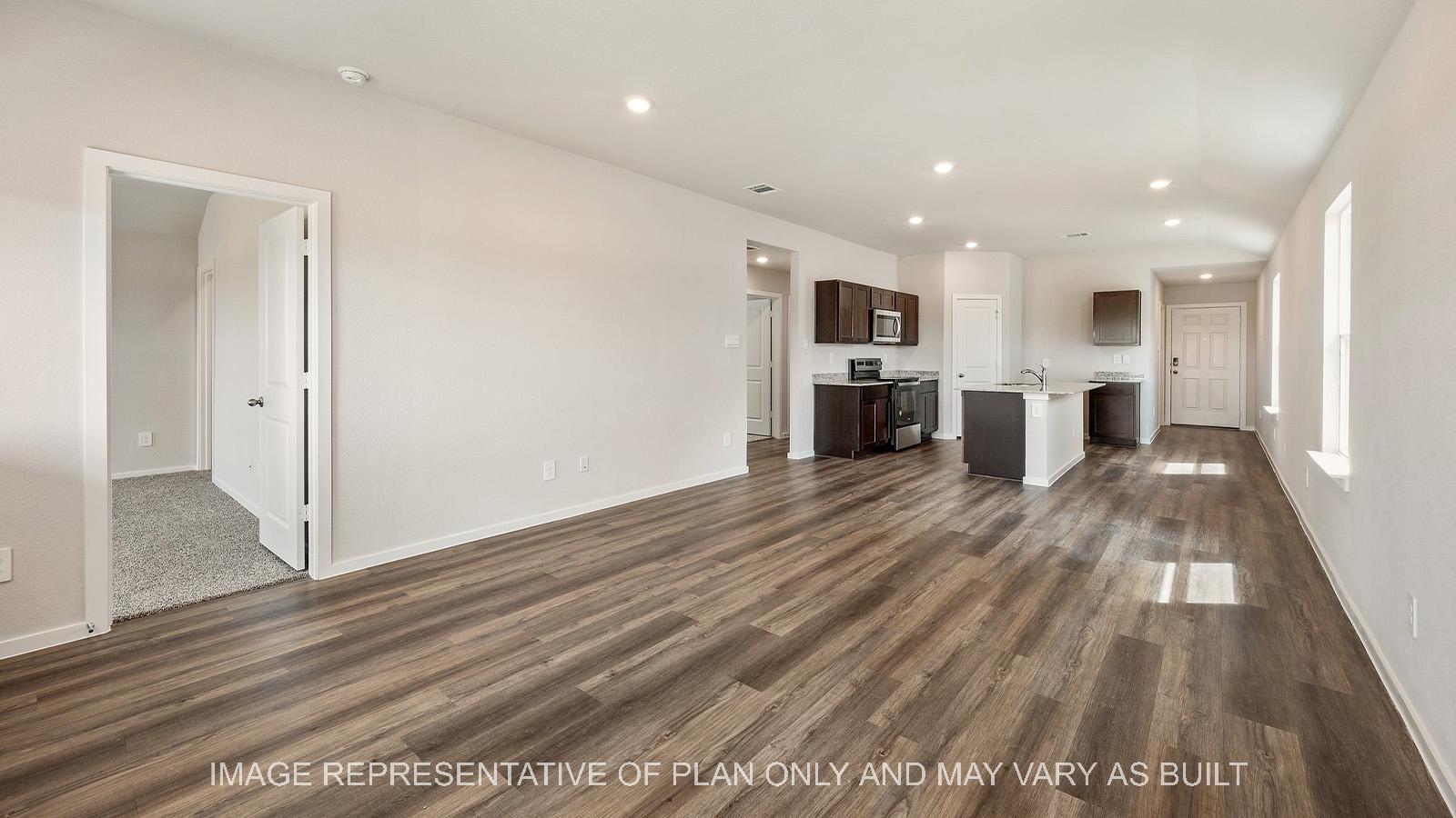 Amber open-concept living with vinyl plank flooring and view to kitchen.