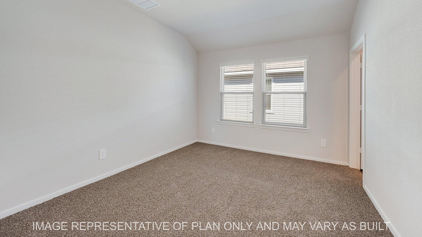 Brooke primary bedroom with windows and carpeted flooring.