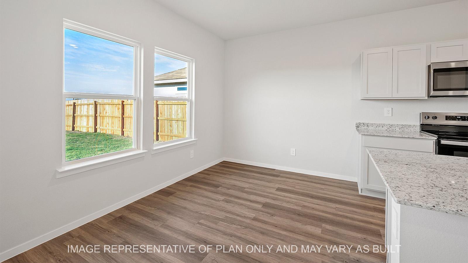 Emma open-concept dining area with two windows to backyard.