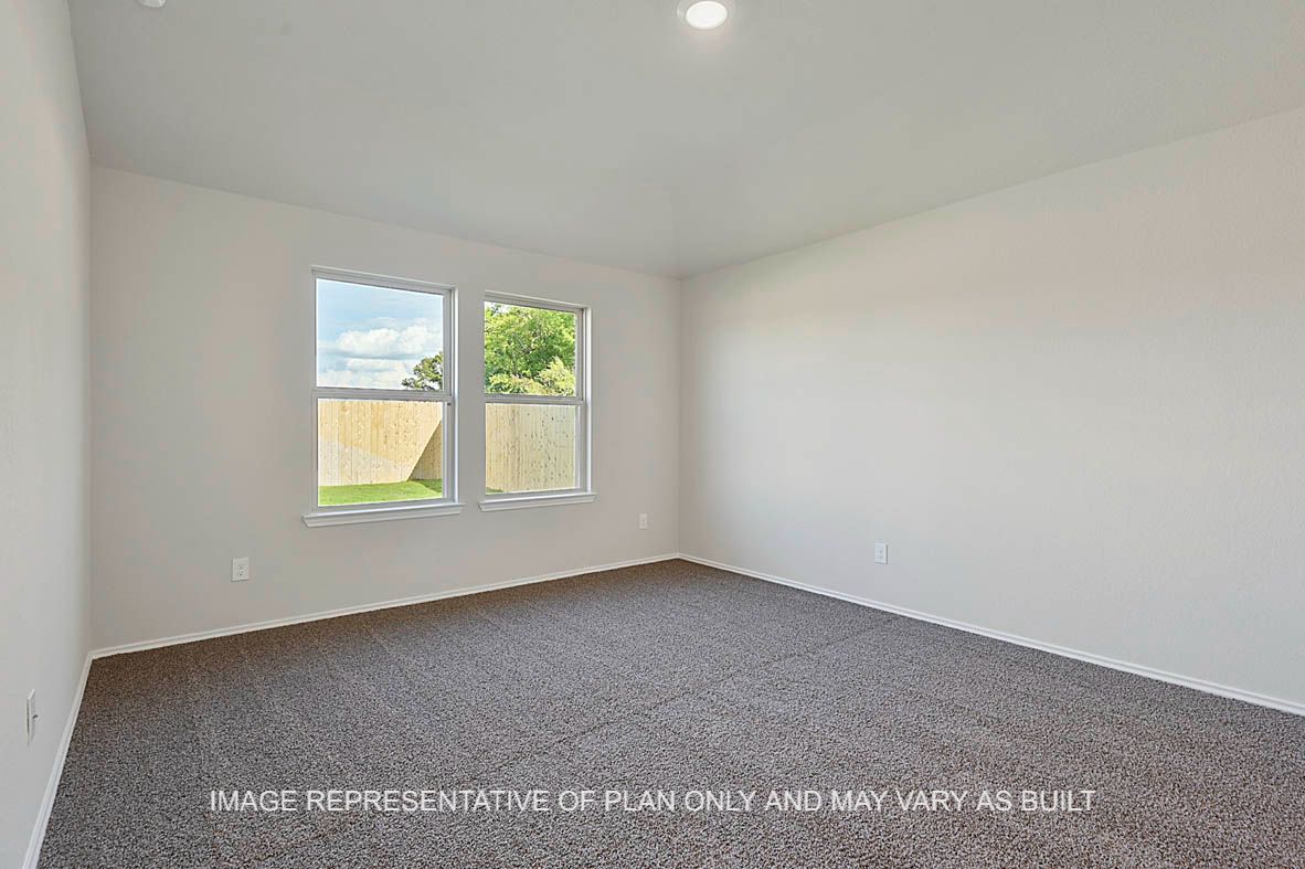 Texas Cali primary bedroom with windows and carpet flooring.