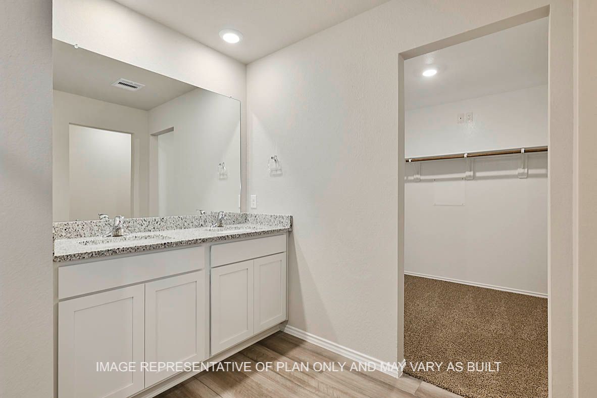 Texas Cali primary bathroom with entry to primary closet with carpet flooring.