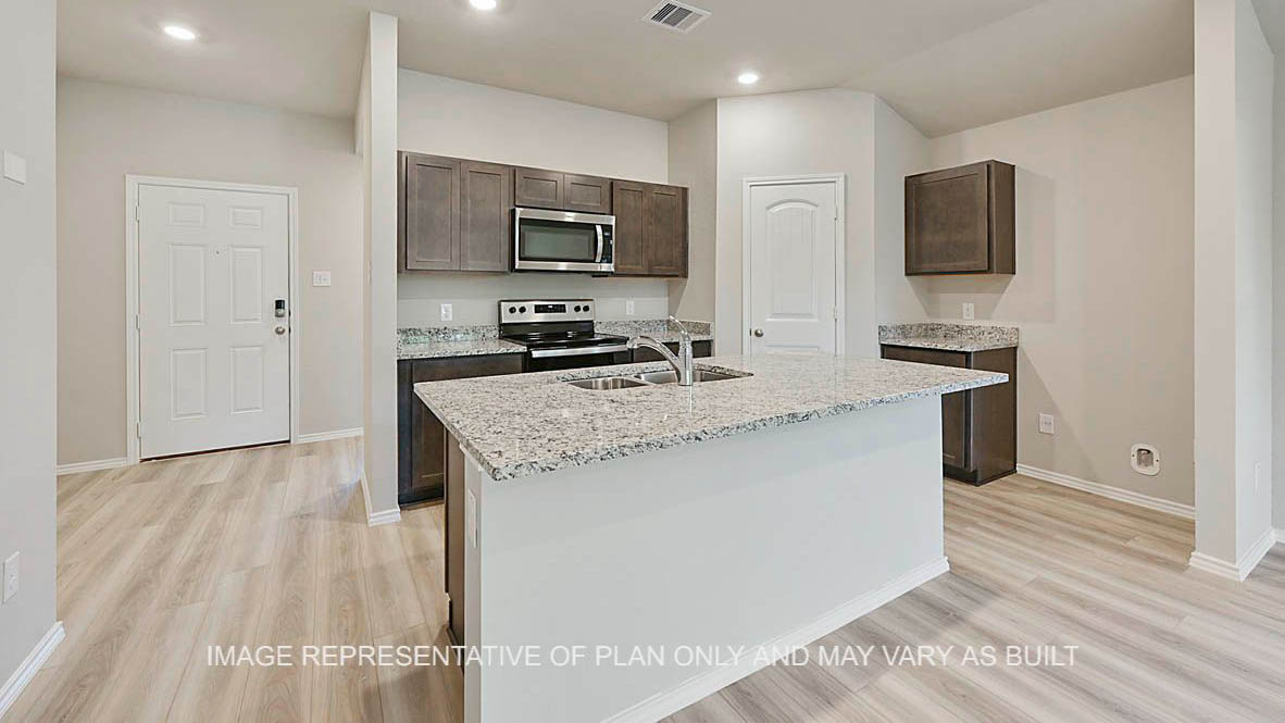 Elgin kitchen with stained cabinetry, granite countertops, kitchen island, vinyl plank flooring, and view to front door.