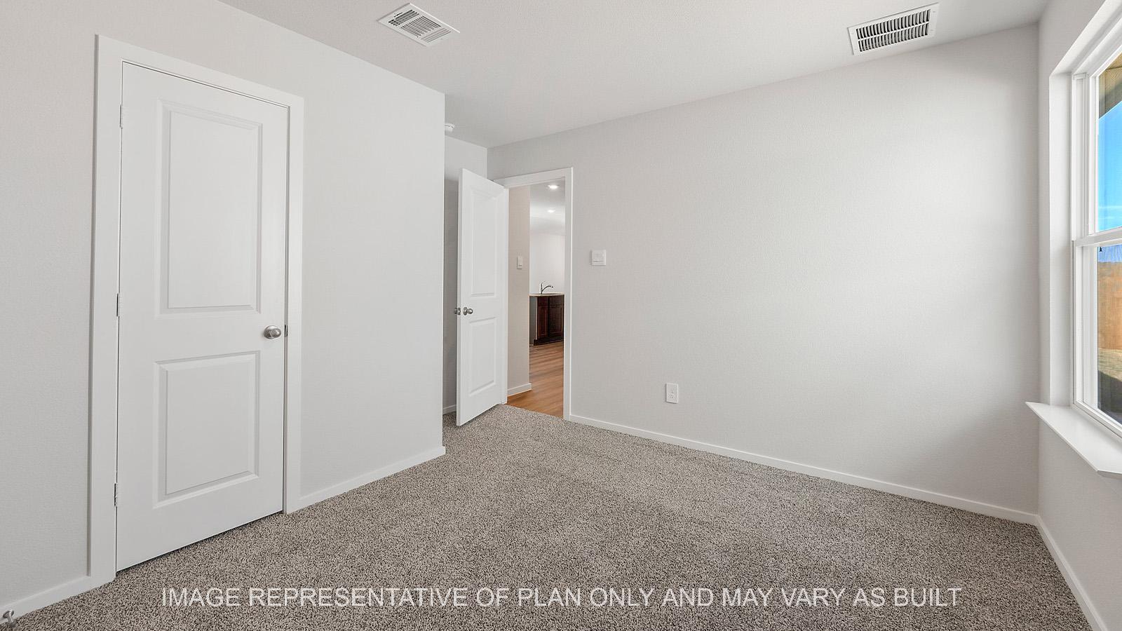 Diana secondary bedroom with walk-in closet, carpeted flooring, and window.