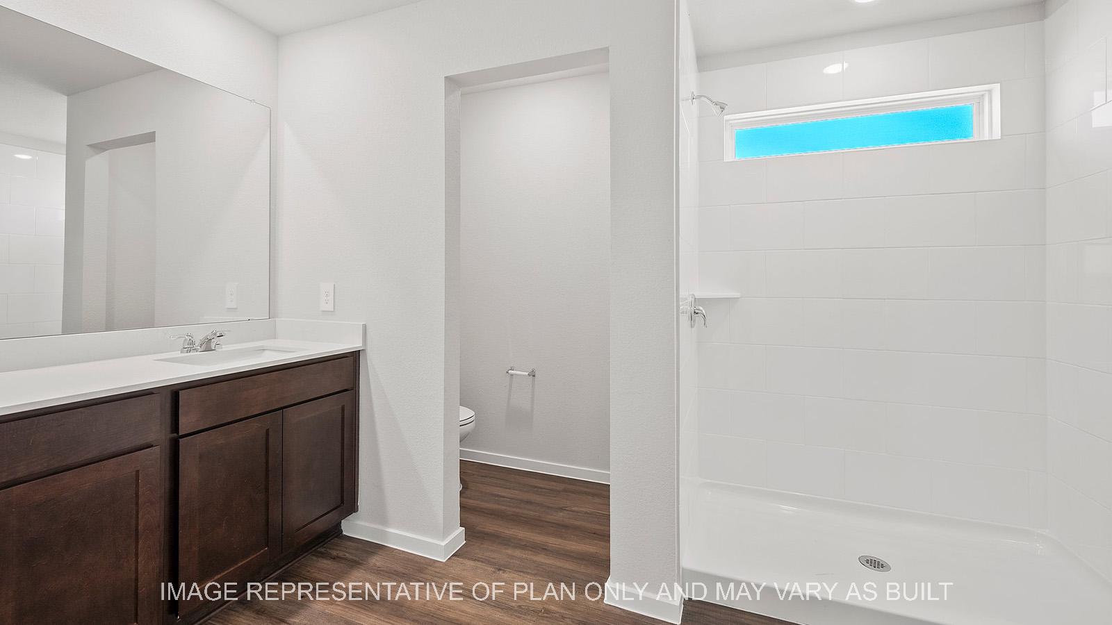 Diana primary bathroom ith dark stained cabinetry and ceramic tile shower surround.