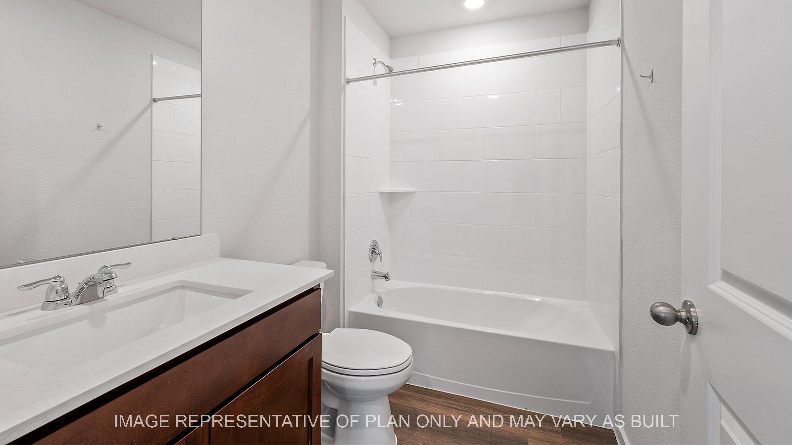 Diana secondary bathroom with stained shaker cabinetry and ceramic tile shower tub combo.