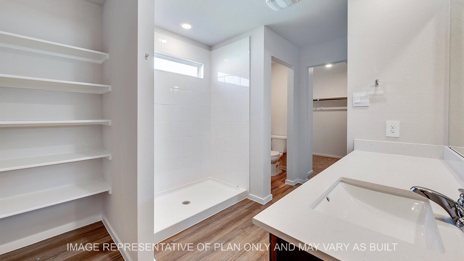 Camden primary bathroom with linen shelving, quartz countertops, and vinyl plank flooring.