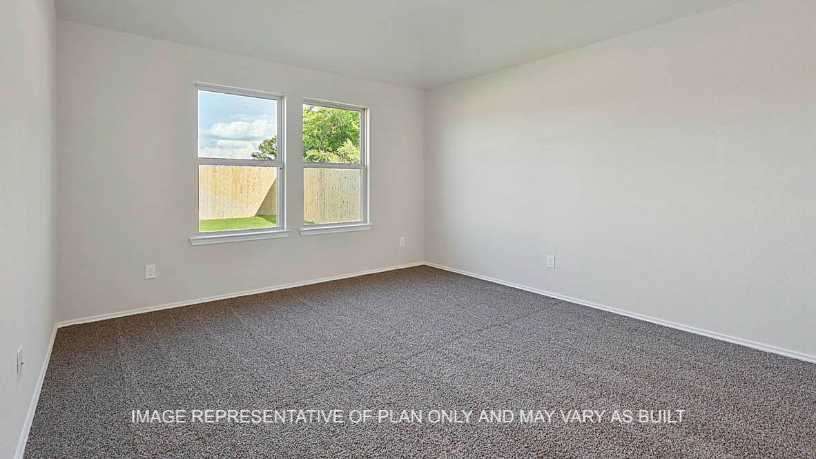 Texas Cali primary bedroom with windows and carpet flooring.