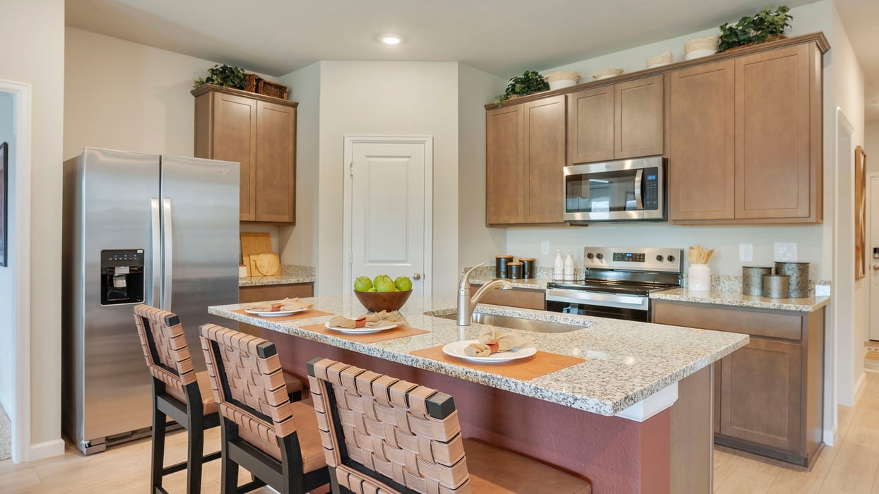 Knox Landing Model Home kitchen with granite countertops and dark stain cabinets
