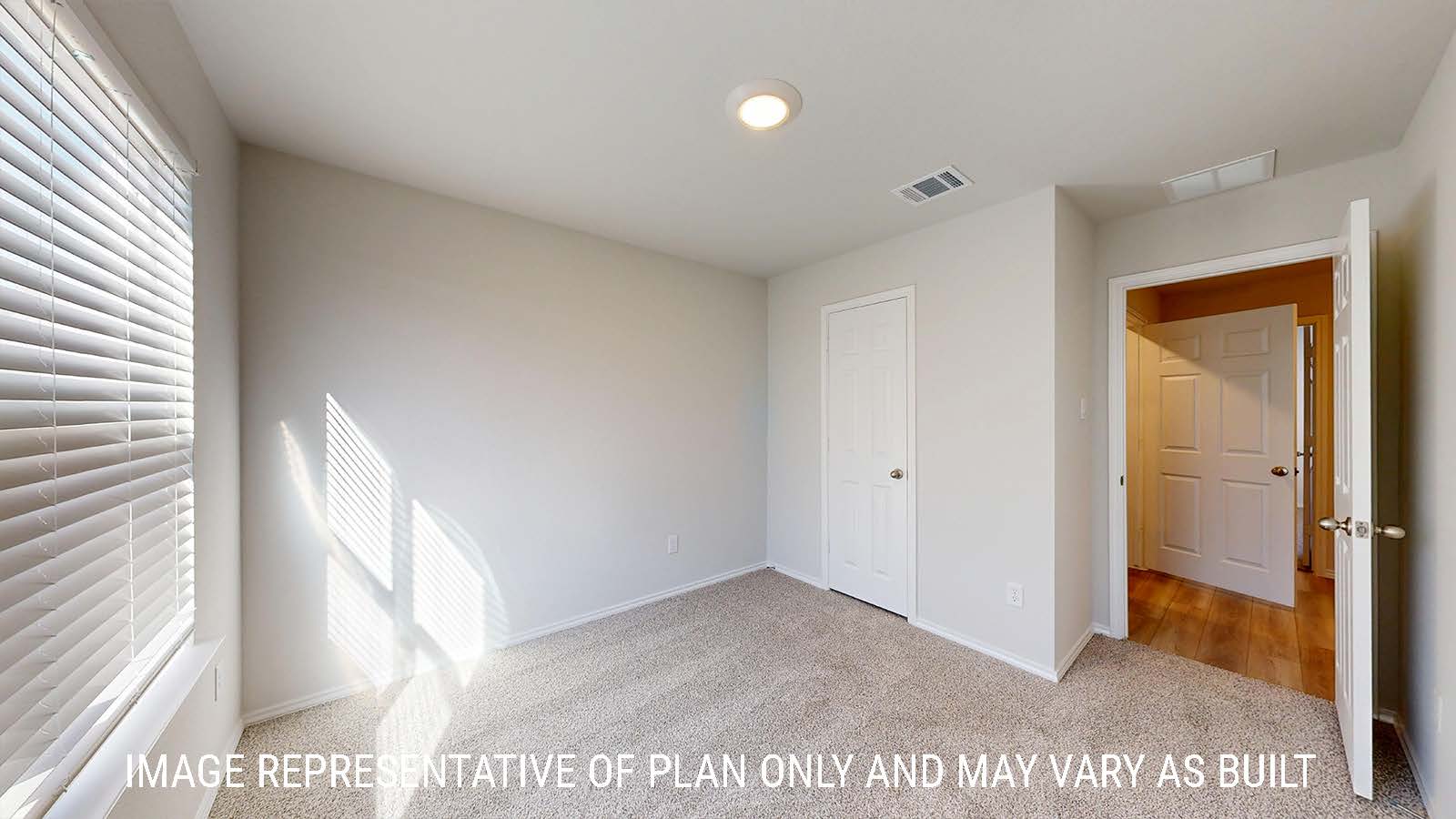 Caden secondary bedroom with carpeted flooring and view of hallway.
