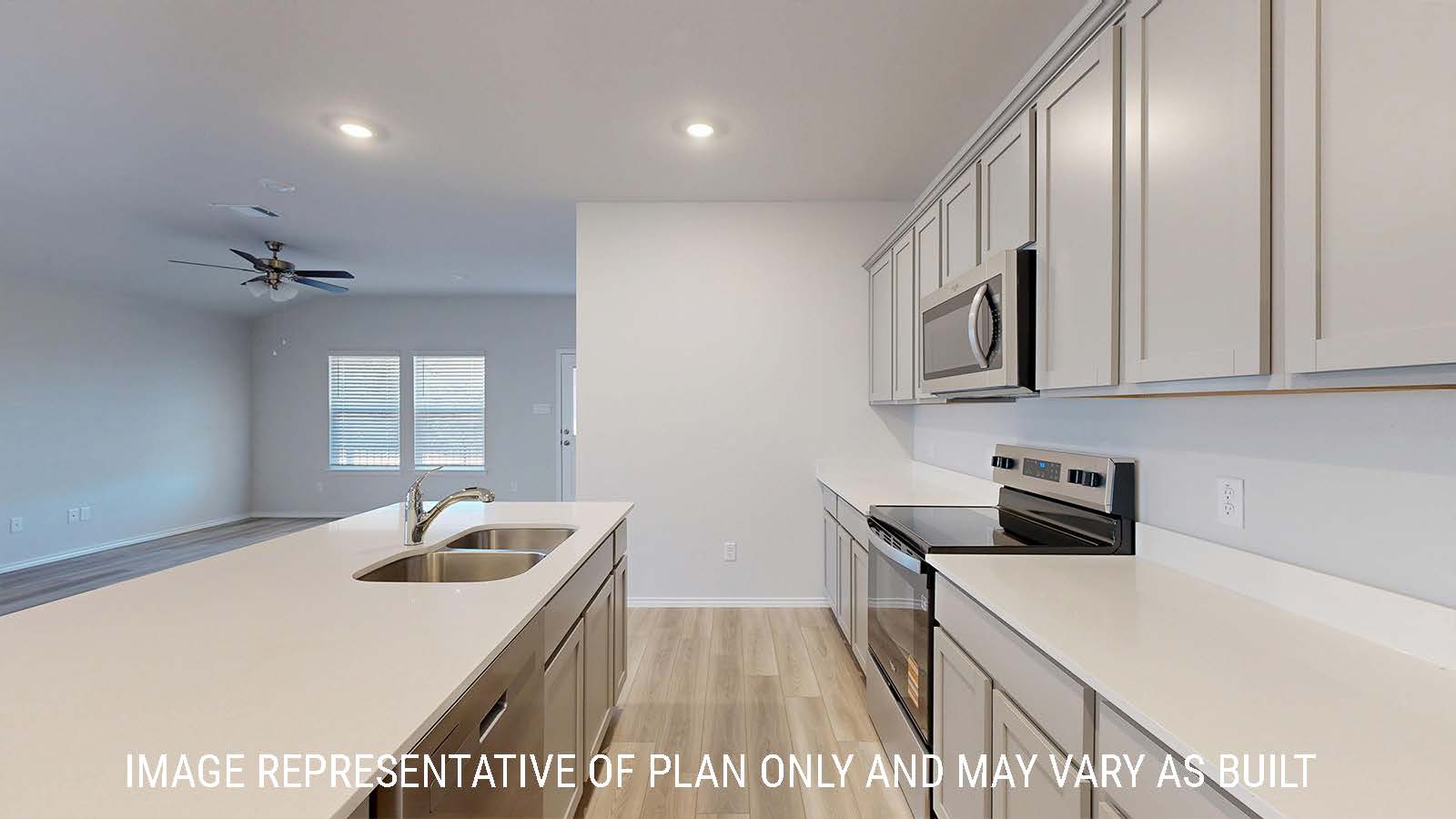 Caden kitchen light cabinets and light countertops with view of living room.