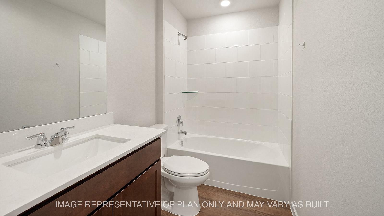 Lakeway secondary bathroom with vinyl plank flooring, quartz countertop, and ceramic tile shower/tub surround.