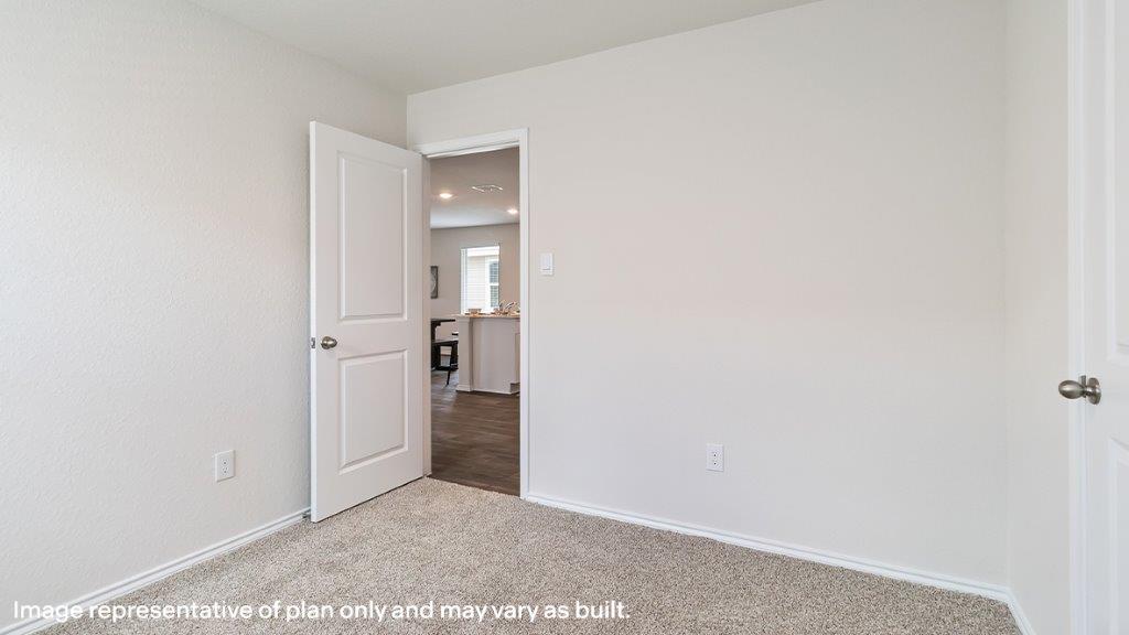 Barton secondary bedroom with carpeted flooring and closet door.