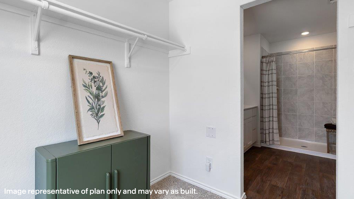Franklin primary walk-in closet with carpeted flooring and view of the primary bathroom.