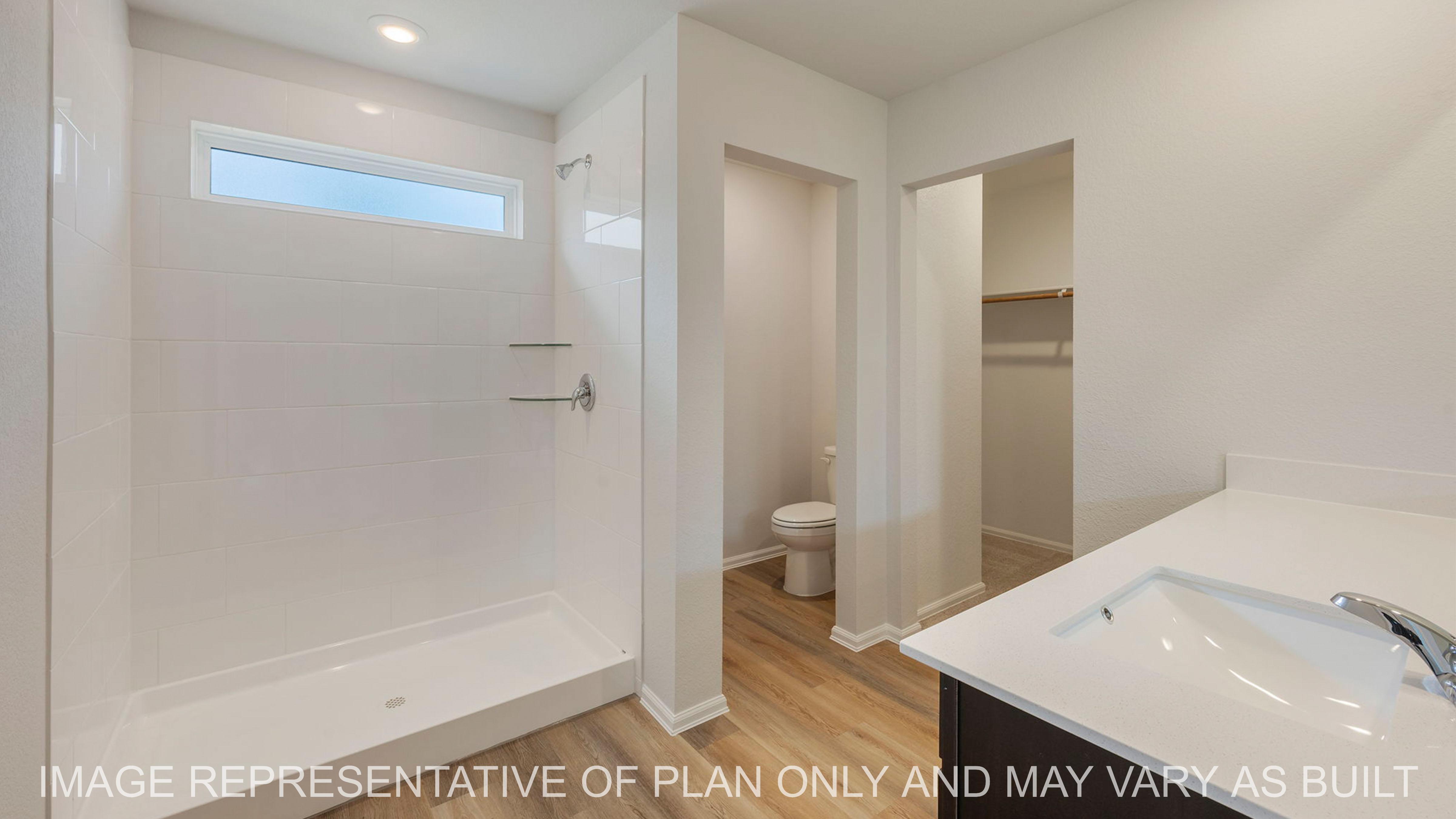 Abbot primary bathroom with tile surround shower and quartz vanity