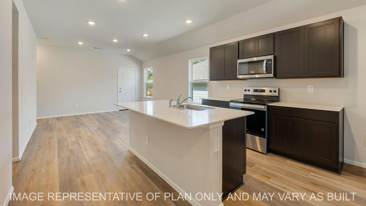 Abbot open concept kitchen with quartz countertop and dark stained cabinetry