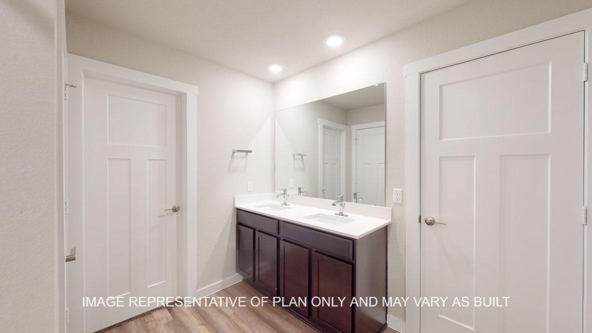 Baxtor primary bathroom with dark cabinets and white countertops.