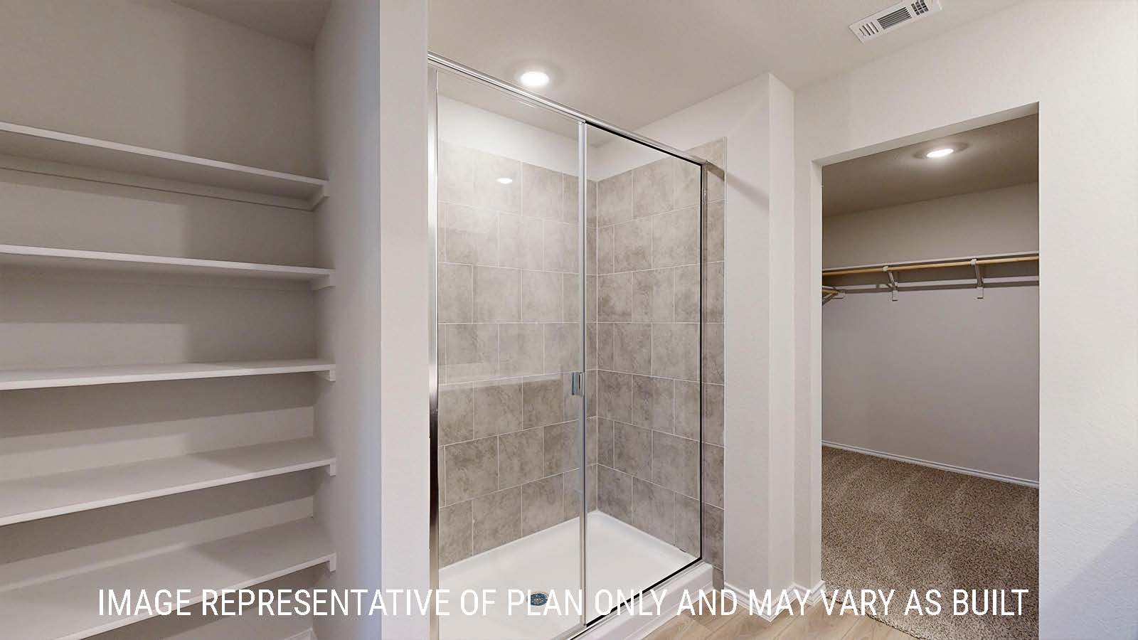 Caden primary bathroom with walk-in shower and shelving for storage with view of primary closet.