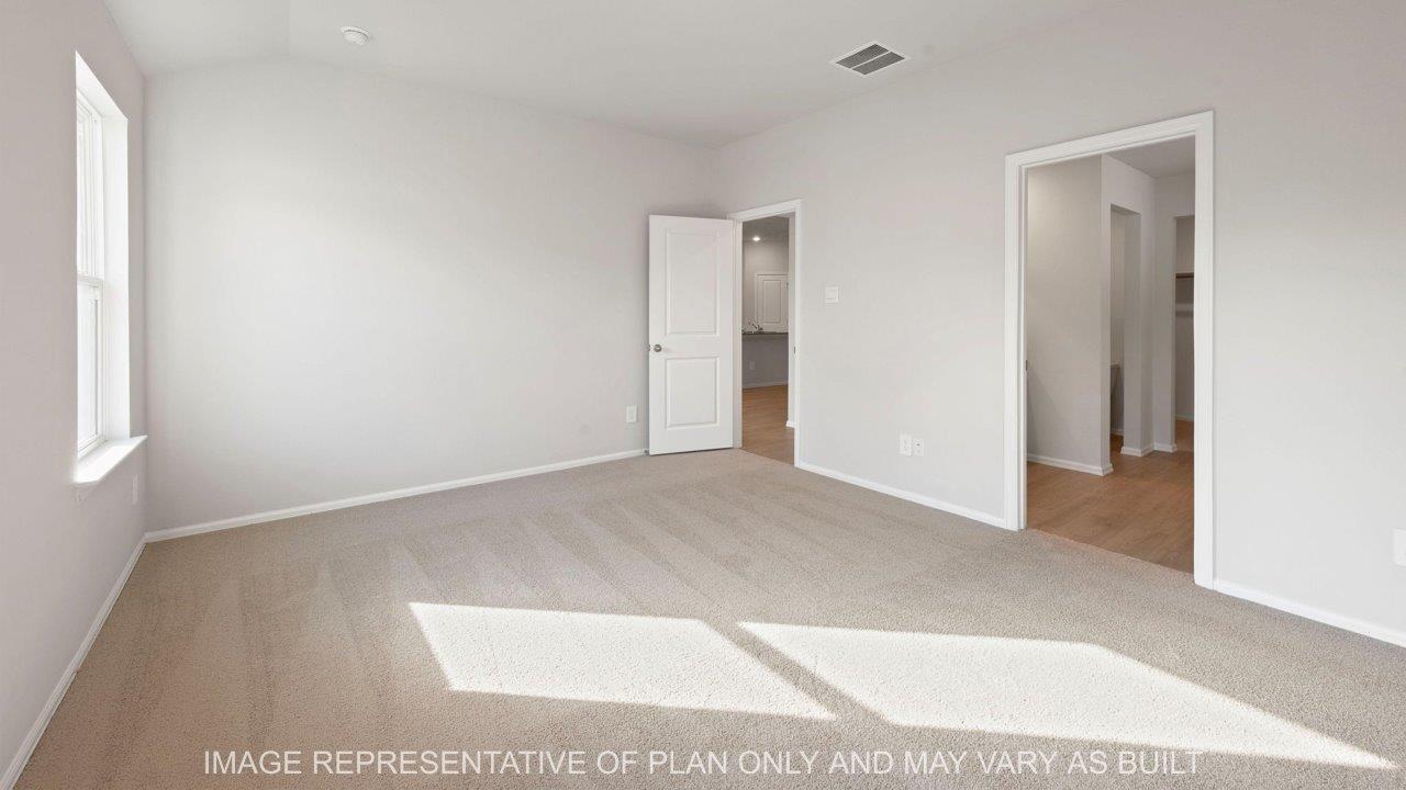 Easton primary bedroom with carpet and windows and entry way