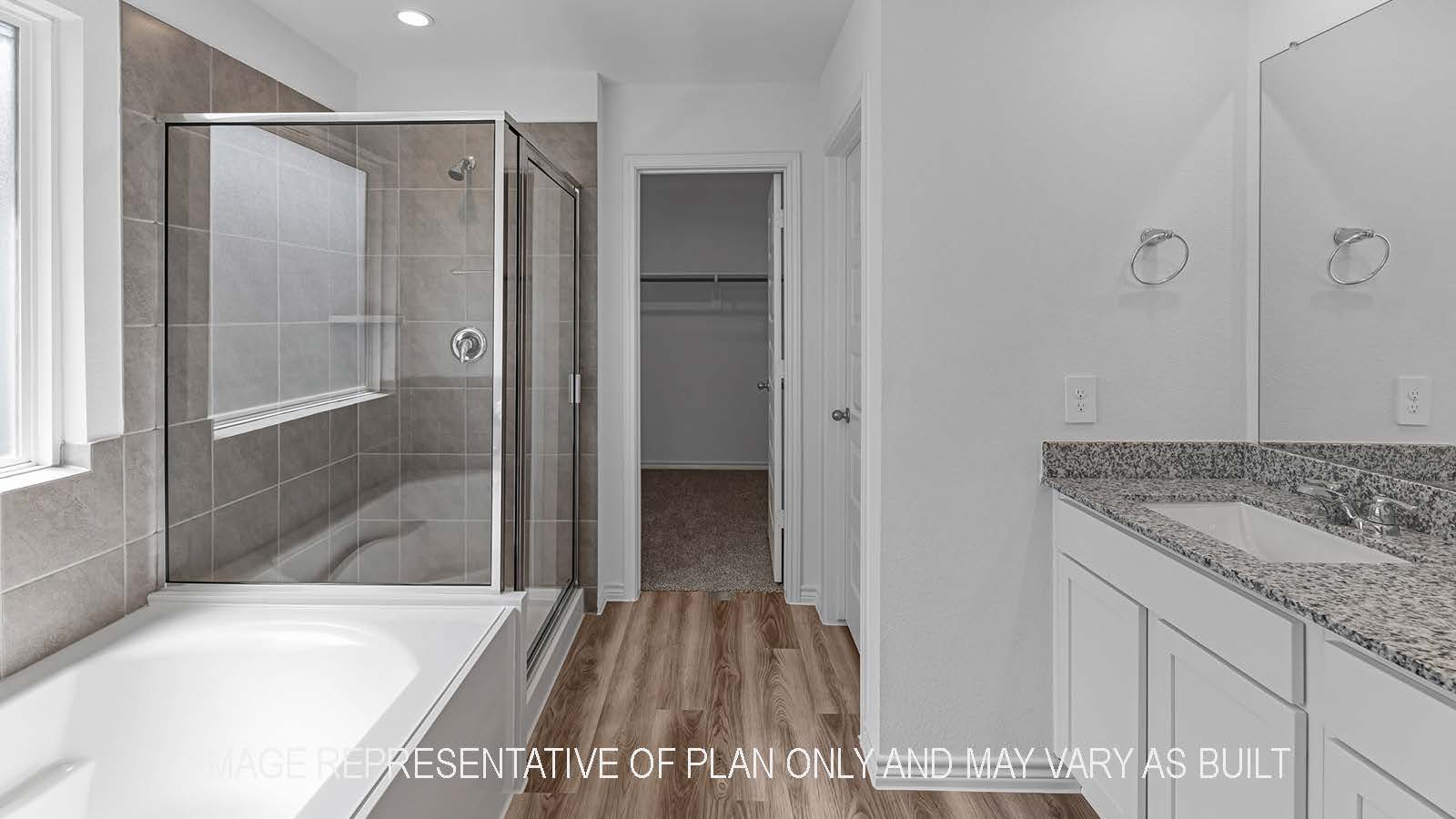 Denton primary bathroom with separate tub and shower and granite countertops.