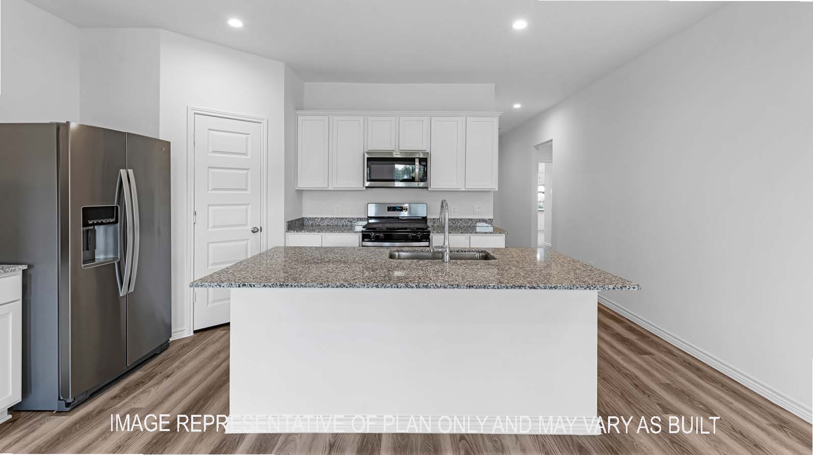Denton kitchen with stainless steel appliances, island, corner pantry, granite countertops, and white shaker cabinetry.