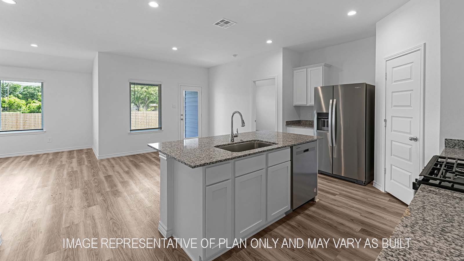 Denton kitchen with stainless steel appliances, island, corner pantry, granite countertops, and white shaker cabinetry.