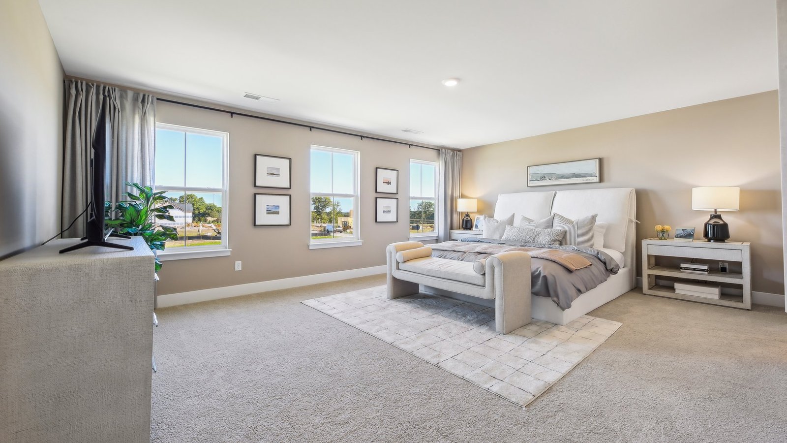 Spacious primary bedroom in a new construction home in Winchester, VA featuring large windows, natural light, and modern design.