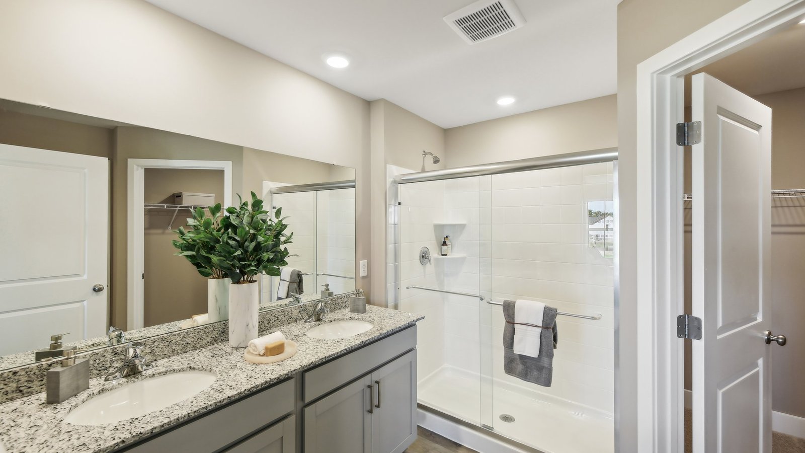 Luxury primary bathroom in a new Winchester VA home with dual vanities, walk-in shower, and contemporary finishes.